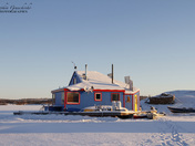 Blue houseboat near an island on Yellowknife Bay in Great Slave Lake