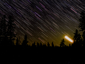 Moon setting and colourful stars in the boreal forest at Riding Mountain National Park