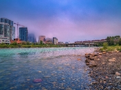 City Train Crossing Under Moody Clouds