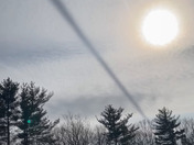 I saw this bizarre dark streak through the sky today about 2:00pm from my work site in Chester, NH