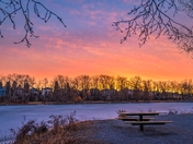 Sunrise Over A Frozen Park Lake