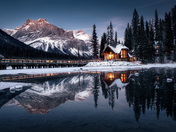 The reflection of the mountain and lodge on the emerald lake