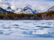 Mountains Reflecting On A Watery Frozen Lake