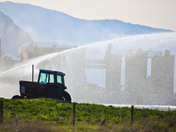 Factory behind the spray of an irrigation plume