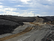 A 400 ton heavy hauler appears minuscule within the massive, open-pit mine.